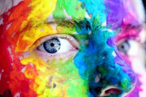From Doodles to Masterpieces: Young Artists Who Made It Big 5 Close-up of a person with colorful rainbow face paint, symbolizing LGBT pride and expression.