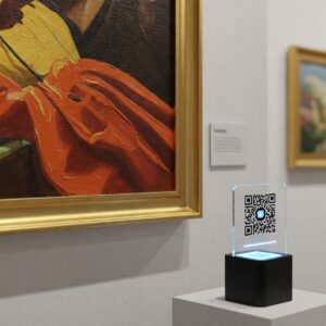 Blockchain Art Explained: How It's Changing Ownership and Provenance 7 A physical sculpture or painting in a gallery setting with a connected digital representation (perhaps a QR code or abstract link symbol) signifying its link to a blockchain token for digital ownership or provenance tracking.