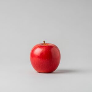 A single red apple on a plain white background, demonstrating the importance of a simple composition for ASCII art