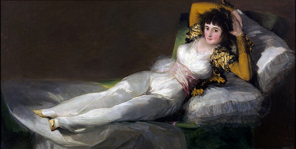 Master of Shadows: Discover the Top 10 Goya Paintings That Changed Art Forever 6 "The Clothed Maja (La maja vestida)" by Goya, painted in c. 1800–1807. Description: This is the companion piece to 'The Nude Maja,' featuring the same woman in the exact same pose, but fully dressed in the stylish clothes of a 'maja' (a term for people from the lower classes of Madrid known for their flamboyant style). The two were likely designed to be displayed together, perhaps with the clothed version hiding the nude one.. Interesting fact: The Clothed Maja was actually painted a few years after The Nude Maja, though the exact reason for its creation remains a mystery.