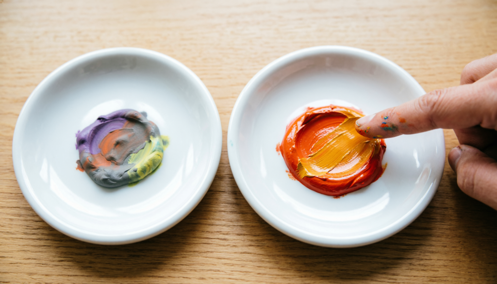 Two paint palettes demonstrating warm and cool color mixing. The left palette shows cool red and yellow creating a muddy, desaturated orange, while the right palette shows warm red and yellow mixing into a clear, vibrant orange.
